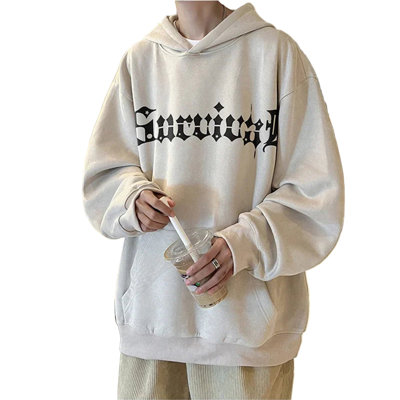 Person wearing a beige hoodie with text in a kitchen setting