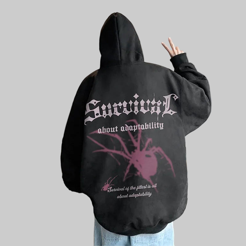 Person wearing a black hoodie with text and a spider graphic, standing in an indoor setting.