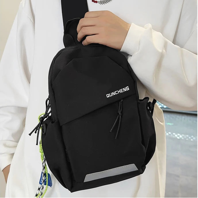 Person wearing a black backpack with 'Quinche' branding against a neutral background
