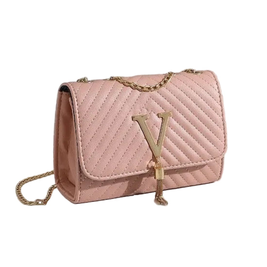 Pink quilted handbag with gold chain on a white surface