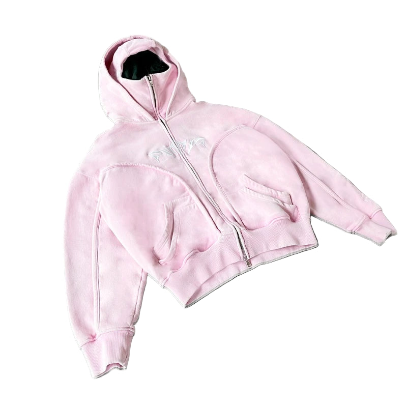 Pink hoodie with a zipper on a gray surface