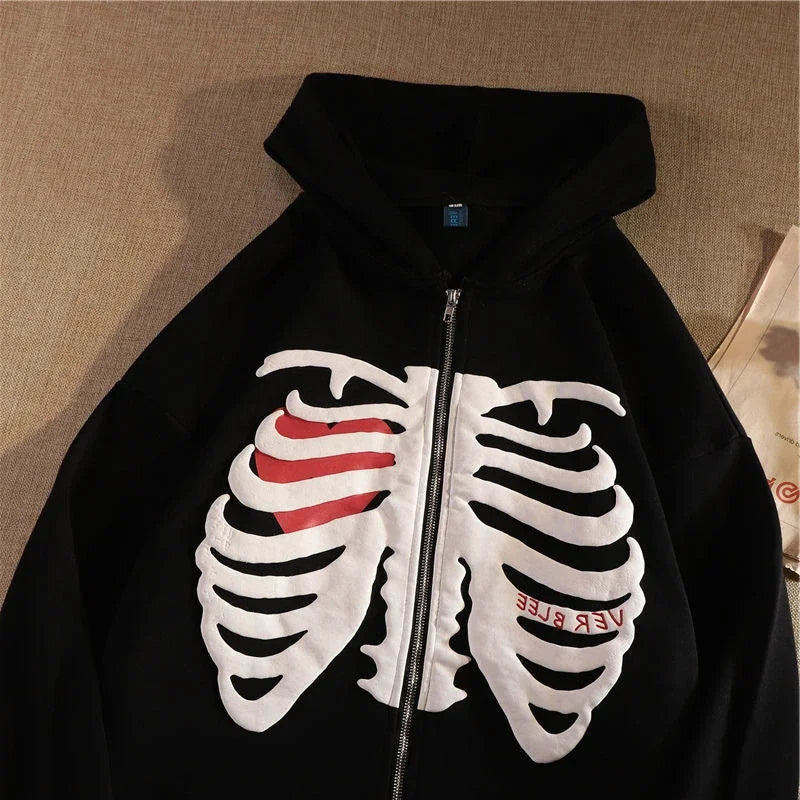 Black hoodie with a white skeleton design and red accents on a beige background