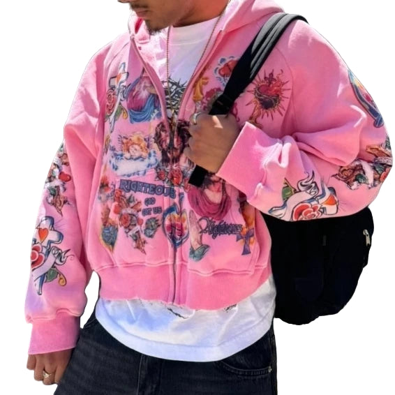 Person wearing a pink hoodie with colorful designs against a black metal fence.