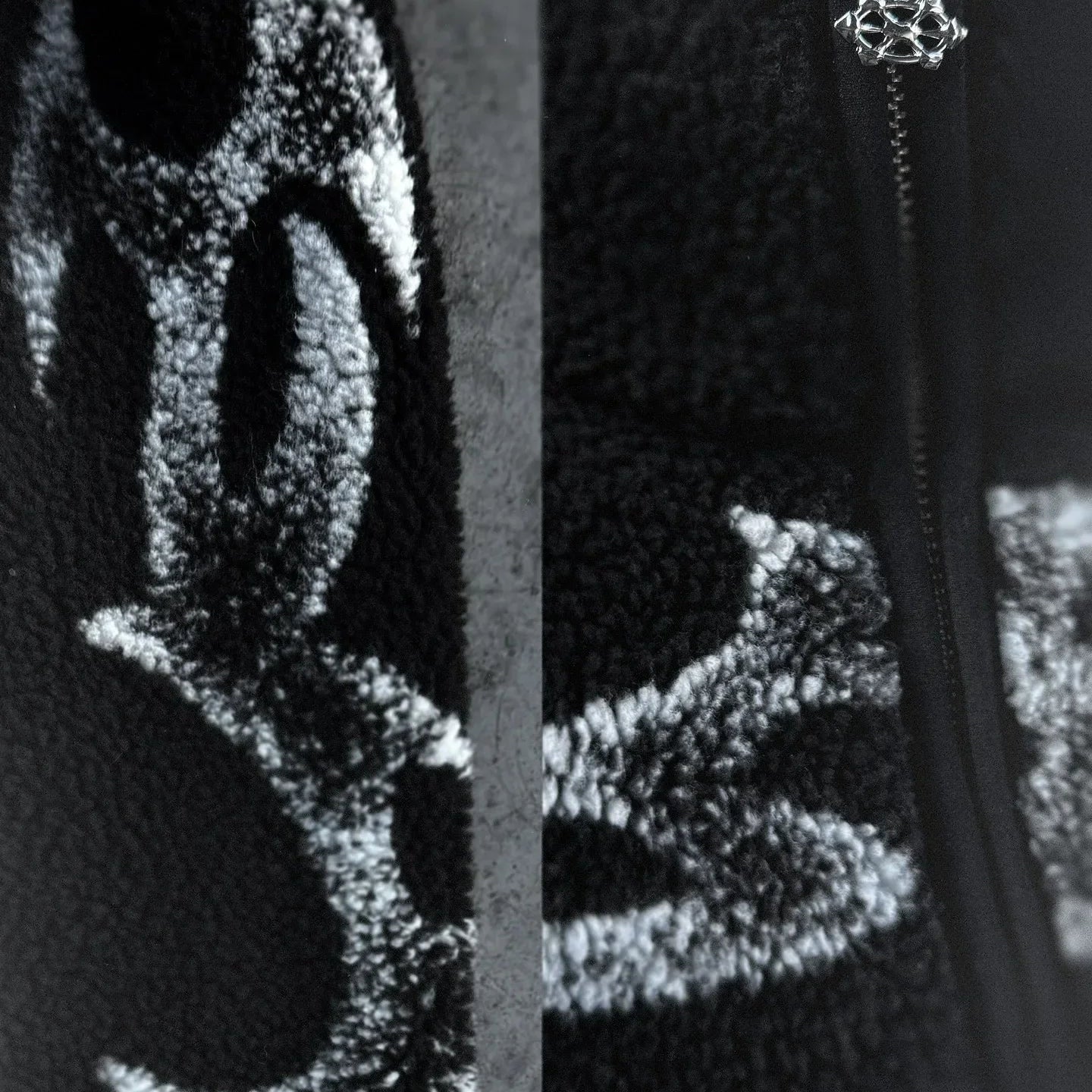 Close-up of a textured black surface with a zipper and decorative element.