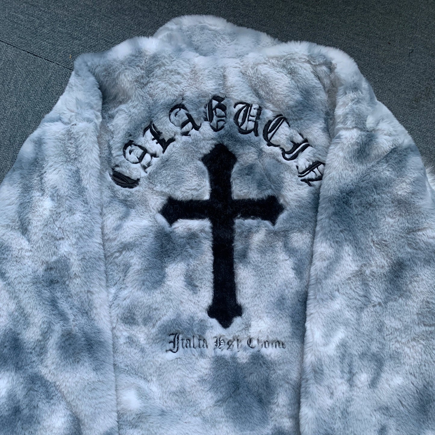 Gray tie-dye hoodie with a black cross and text on a dark background