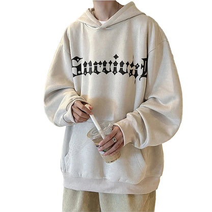 Person wearing a beige hoodie with text in a kitchen setting