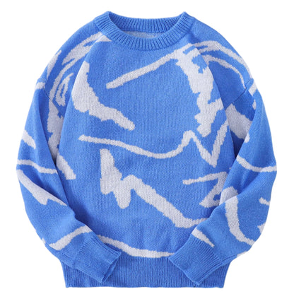 Blue sweater with white abstract patterns on a gray surface with a white textured background