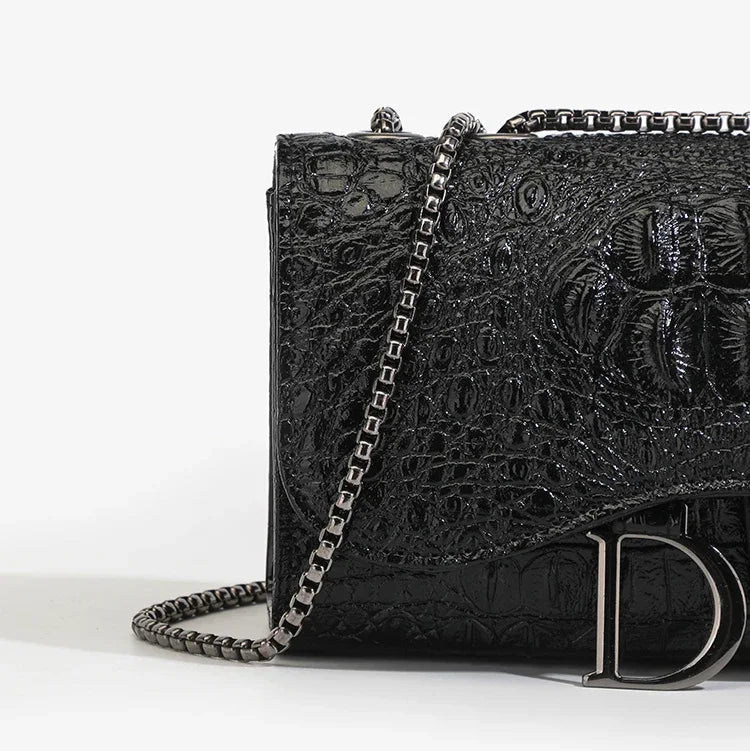 Black textured handbag with chain strap on a white background