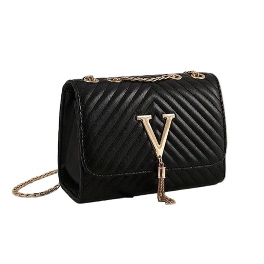 Black quilted handbag with gold accents on a white surface