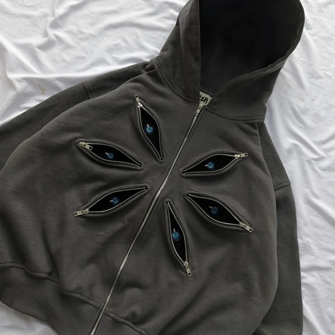 Dark gray hoodie with eye-shaped zippers on a white background