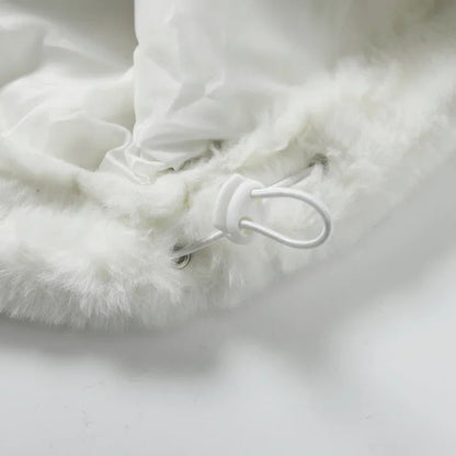 Close-up of a fluffy white blanket with a button on a light gray background