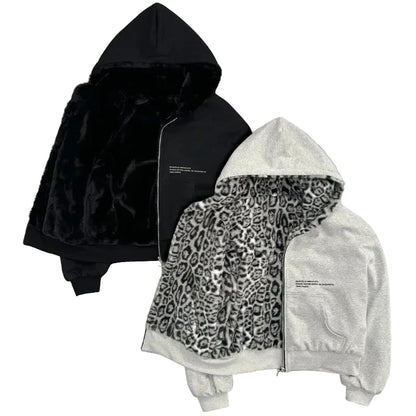 Two hoodies, one black and one with a leopard print pattern, on a gray surface.