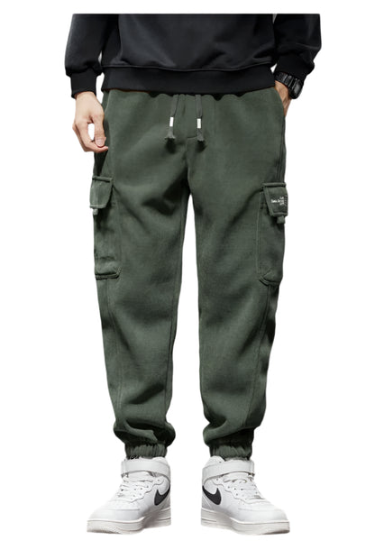 Person wearing green cargo pants and white sneakers on a white background