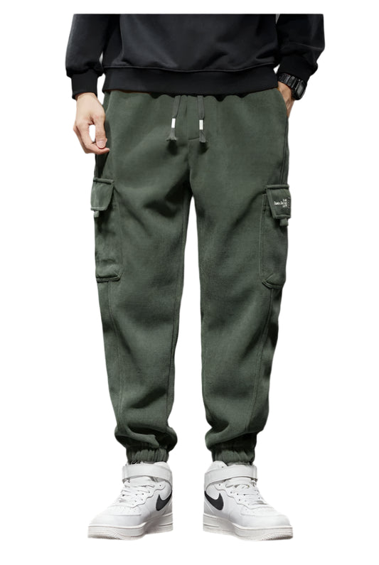 Person wearing green cargo pants and white sneakers on a white background