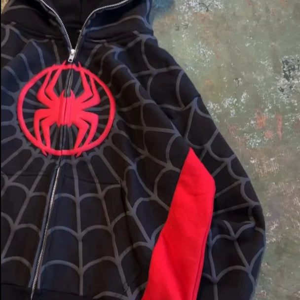 Black hoodie with red spider emblem on a textured surface