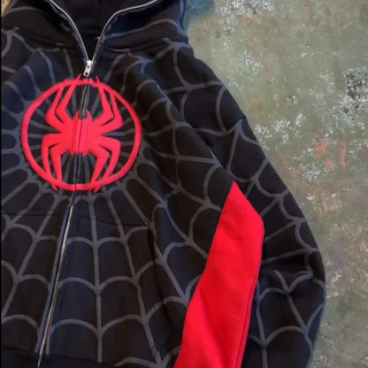 Black hoodie with red spider emblem on a textured surface
