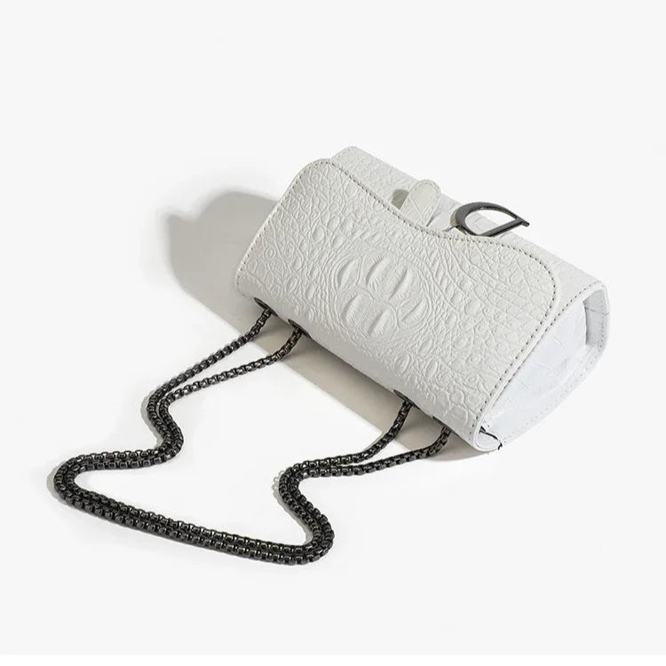 White textured handbag with a black chain strap on a white background