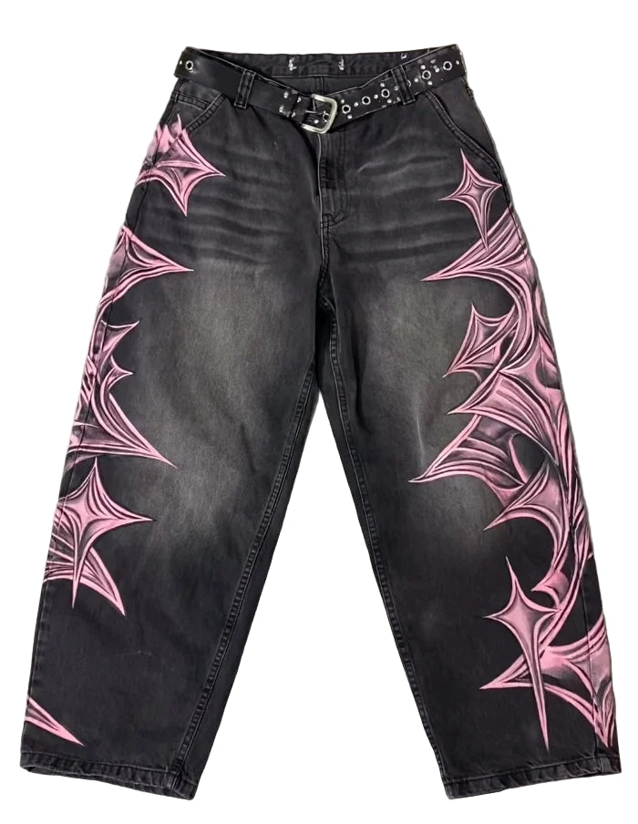 Black jeans with pink spider web designs on a gray surface