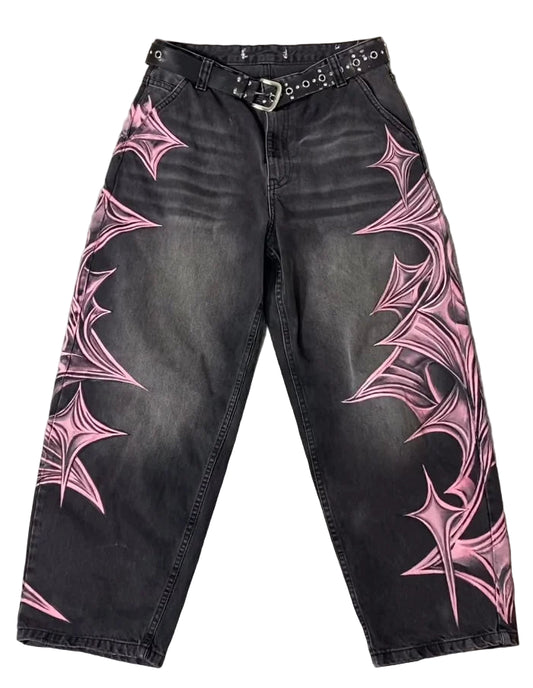 Black jeans with pink spider web designs on a gray surface