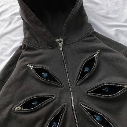 Dark gray hoodie with eye-shaped zippers on a white background