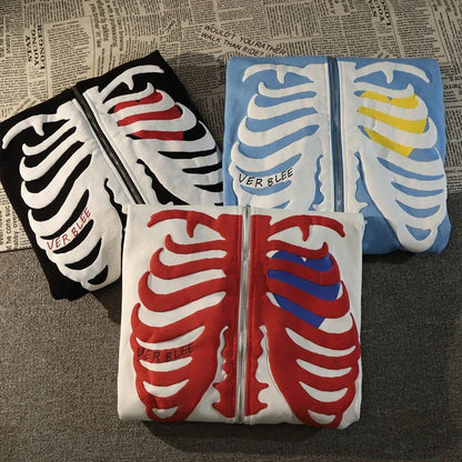 Three folded shirts with skeleton designs on a textured surface