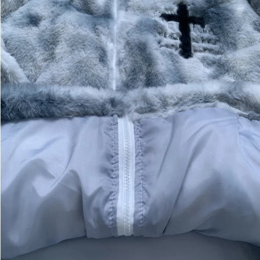 Close-up of a textured fabric with a cross emblem and white zipper.