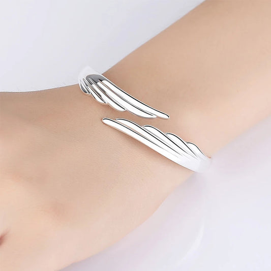 Silver bracelet on a wrist against a light background