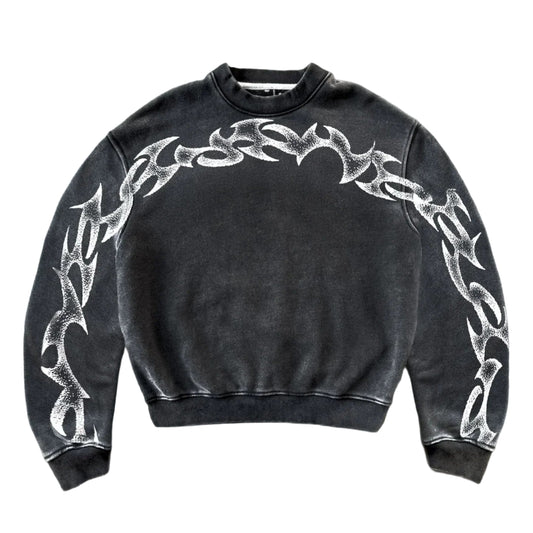 Black sweatshirt with white tribal designs on a gray concrete floor