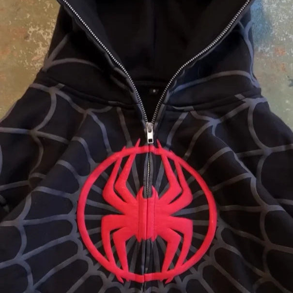 Black hoodie with red spider emblem on a textured surface