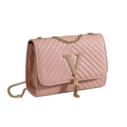 Pink quilted handbag with gold chain on a white surface