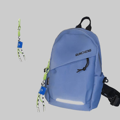 Blue backpack with 'QUNCHENG' branding on a white surface with a magazine in the background.