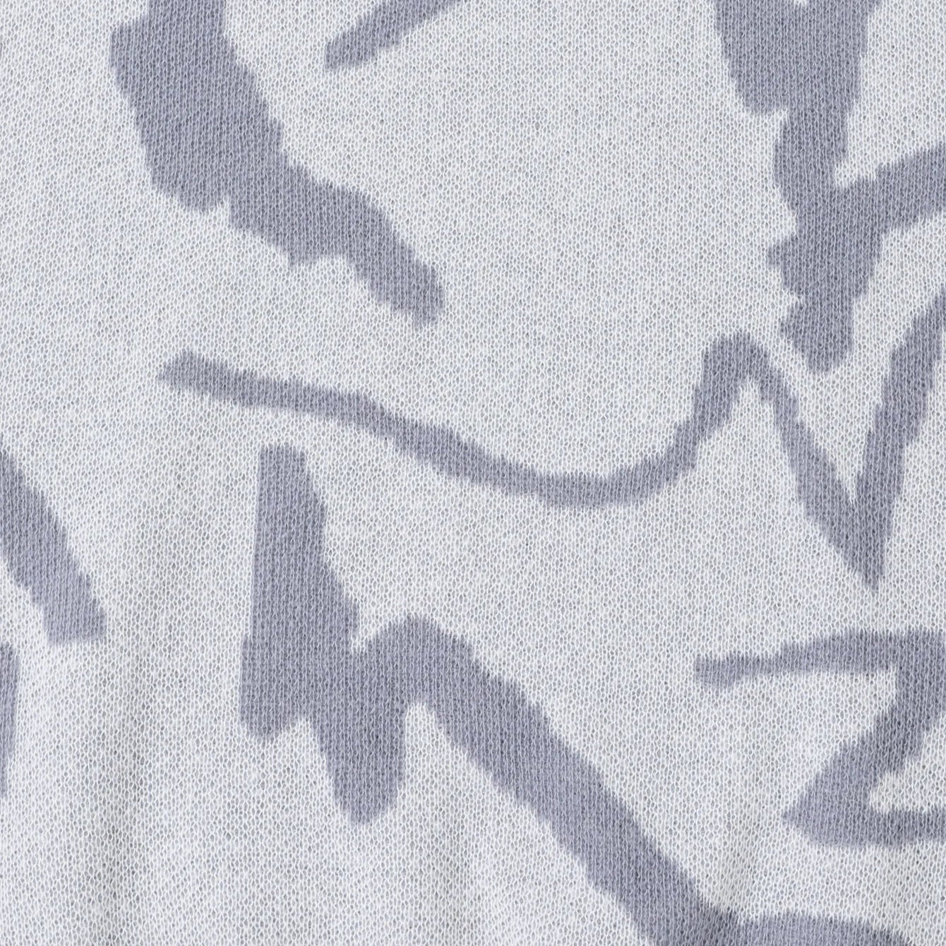 Close-up of a fabric with abstract black patterns on a light gray background