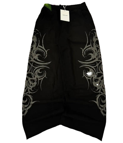Black skirt with silver tribal patterns on a gray surface