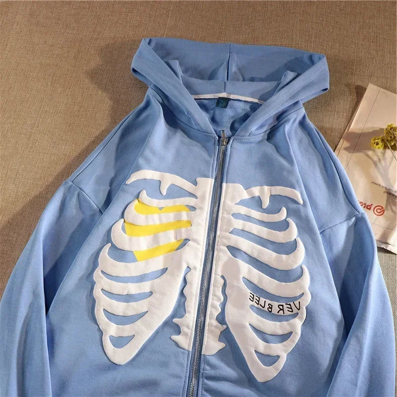 Blue hoodie with skeleton design on a beige surface