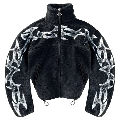 Black jacket with white tribal patterns on a gray concrete surface