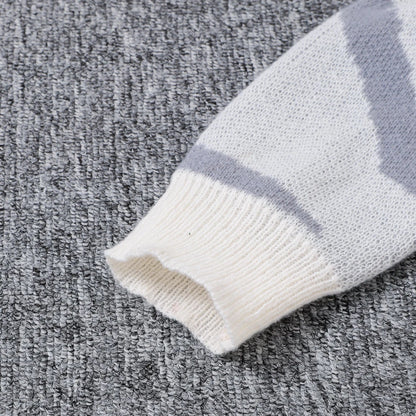 Close-up of a striped sweater sleeve on a textured gray surface