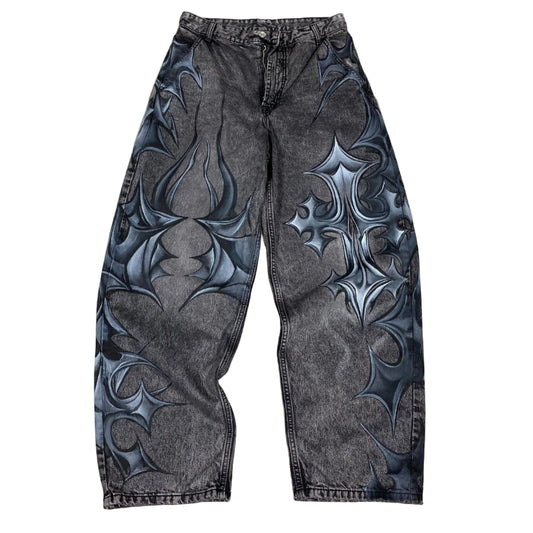 Black and gray patterned pants on a concrete floor