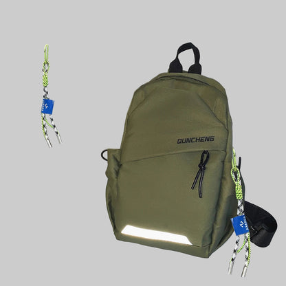 Green backpack with reflective strip on a white surface with accessories in the background