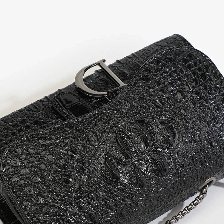 Black textured handbag with a silver buckle on a white background
