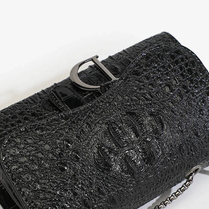 Black textured handbag with a silver buckle on a white background