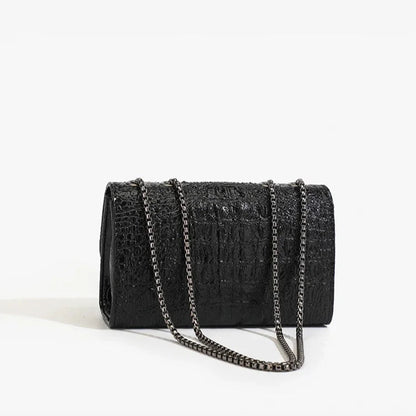 Black textured clutch bag with a chain strap on a white background