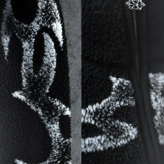 Close-up of a textured black surface with a zipper and decorative element.