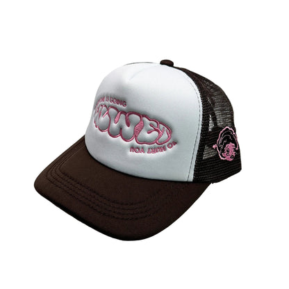 White and brown cap with pink logo on a white surface