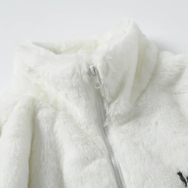 Close-up of a white fleece jacket with a zipper on a light gray background