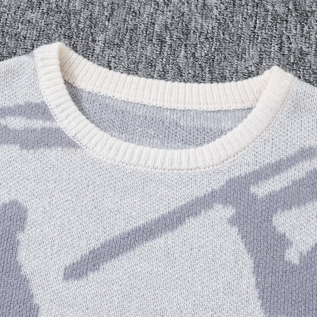 Close-up of a sweater with a pattern on a textured gray background