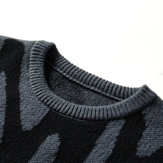 Close-up of a dark gray sweater with a pattern on a white background