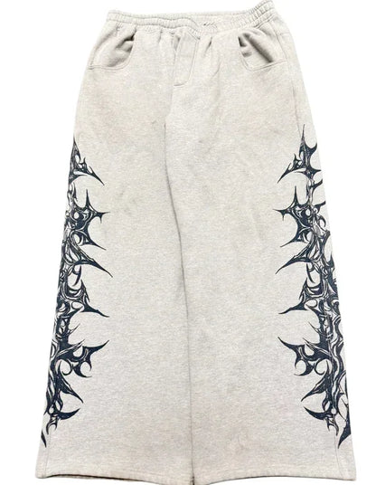Gray sweatpants with black tribal designs on a white background